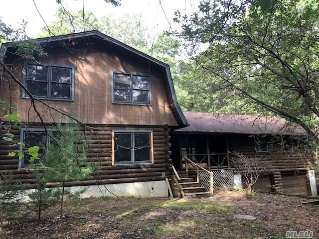 Rustic Log Cabin Situated On A Quiet And Secluded 1.29 Acres Of Property. Home Boasts Wood Floors Throughout Large Eat-In-Kitchen For Entertaining, Cozy Up To The Wood Burning Stove In Your Huge Living Room, Sit On Your Front Deck And Enjoy The Wild Outdoors. Master Suite Upstairs And 3 Additional Bedrooms With That. Large Unfinished Basement With 2 Car Garage Access. Located In The Desirable Miller Place School District. Don't Let This One Pass You By! Sold As-Is.