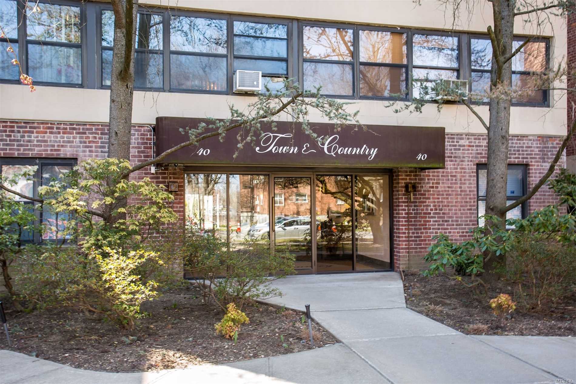 Fantastic 2BR/2Bath with front-facing terrace and open layout in desirable co-op with low maintenance and guaranteed parking close to LIRR and Town. Formal DR could be 3rd bedroom. This is one flight up from lobby floor. Update this apartment and make it your dream home!