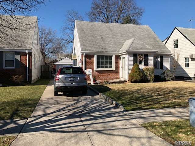 Wide Cape On Beautiful Block. Walk To City Bus And Bay Terrace Shopping Plaza! Original 3 Bedroom Converted To Two, (Easy To Convert Back). Hardwood Floors Under Carpet,  Sunny Eat In Extension Off Kitchen,  Detached 1.5 Car Garage With Plenty Of Parking In Driveway.