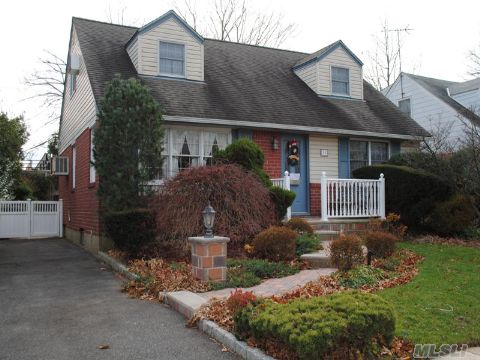 Brick Center Hall Wide Line Cape. The First Floor Features Hallway, Living Room, Formal Dining Room, Kitchen, Full Bathroom, And Two Nice Sized Bedrooms.  The Second Floor Has Two Big Bedrooms, There Is Hardwood Floor Throughout Including The Second Floor. Basement Is Finished With A Bar. This House Offers All Updated Windows, Inground Sprinkler System And Gas Heat.