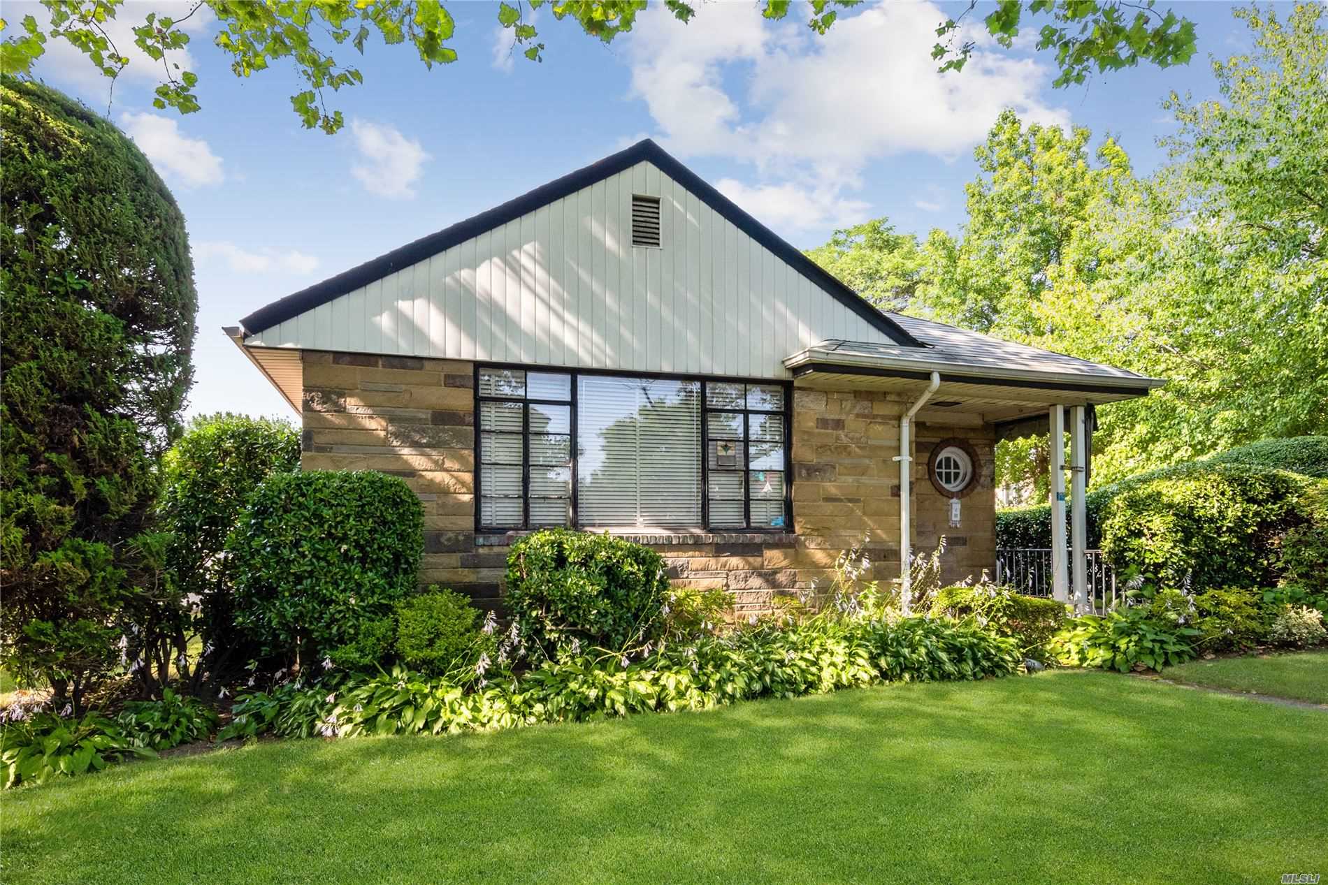 CHARMING BRICK AND STONE RANCH with lots of curb appeal and a detached garage sits on beautifully manicured property in a quiet neighborhood. A bright foyer welcomes you to this cheerful home with stunning molding and wainscoting, arched doorways, and floods of natural light throughout. Entertain guests in the large and inviting living room. Stylish master bedroom suite boasts a private powder room. Two additional sunny bedrooms each have ample closet space, and a full bath is across the hall.