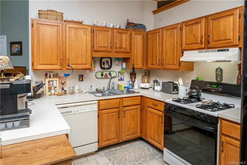 Convenient kitchen with propane range and dishwasher, tile floor.